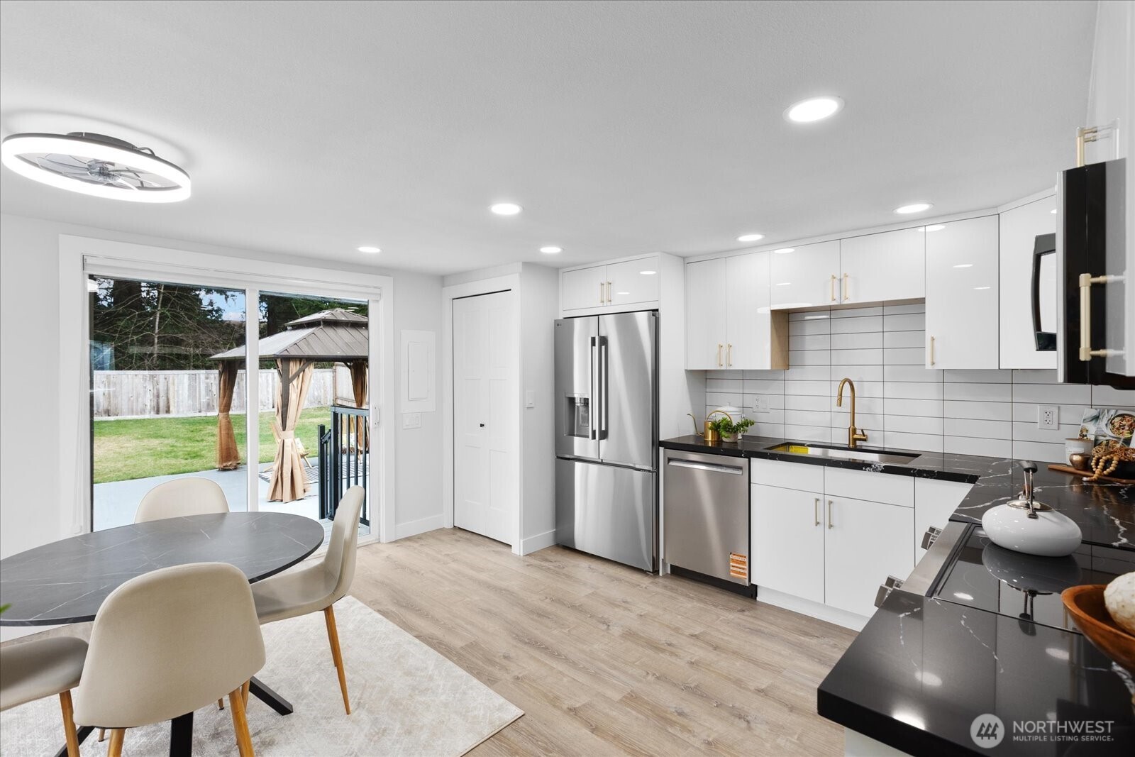 701 Pecks Drive Everett, WA 98203 - Photo 13 of 36 a kitchen with stainless steel appliances granite countertop a stove a refrigerator a sink a dining table and chairs with wooden floor