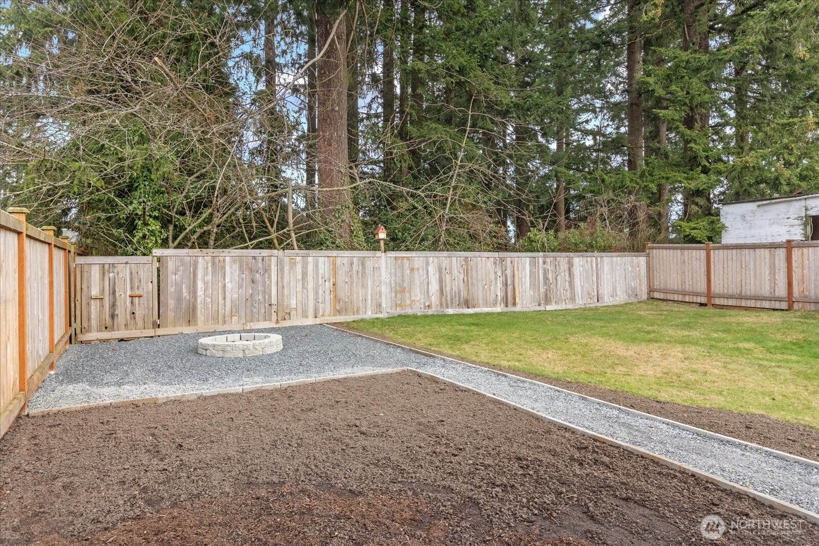 701 Pecks Drive Everett, WA 98203 - Photo 31 of 36 a view of a backyard with large trees and wooden fence