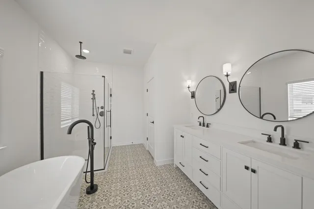 a bathroom with 2 sink tub and a mirror