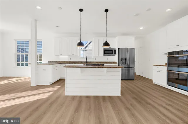 a kitchen with granite countertop white cabinets and white appliances