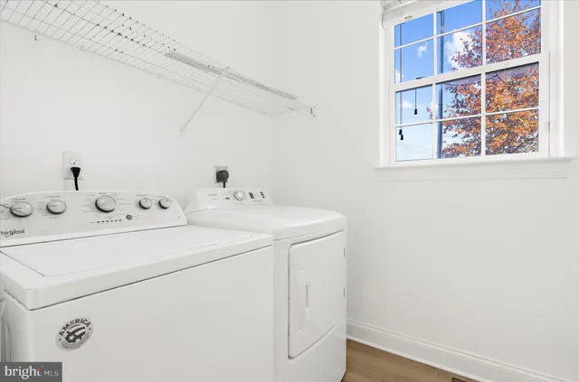 a view of an empty room with window and a ceiling fan