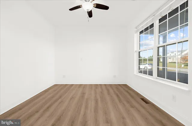 a view of empty room with wooden floor and fireplace