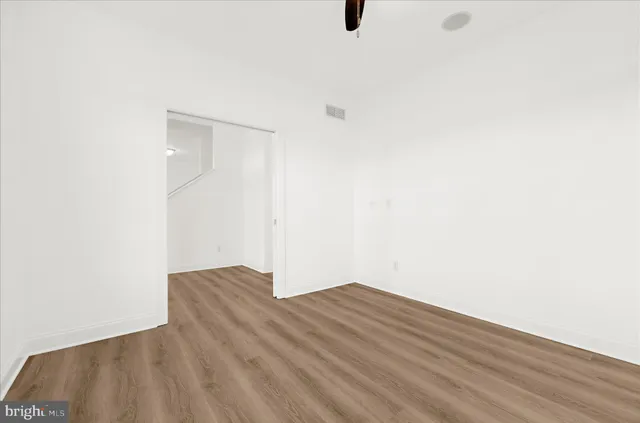 an empty room with wooden floor and fireplace