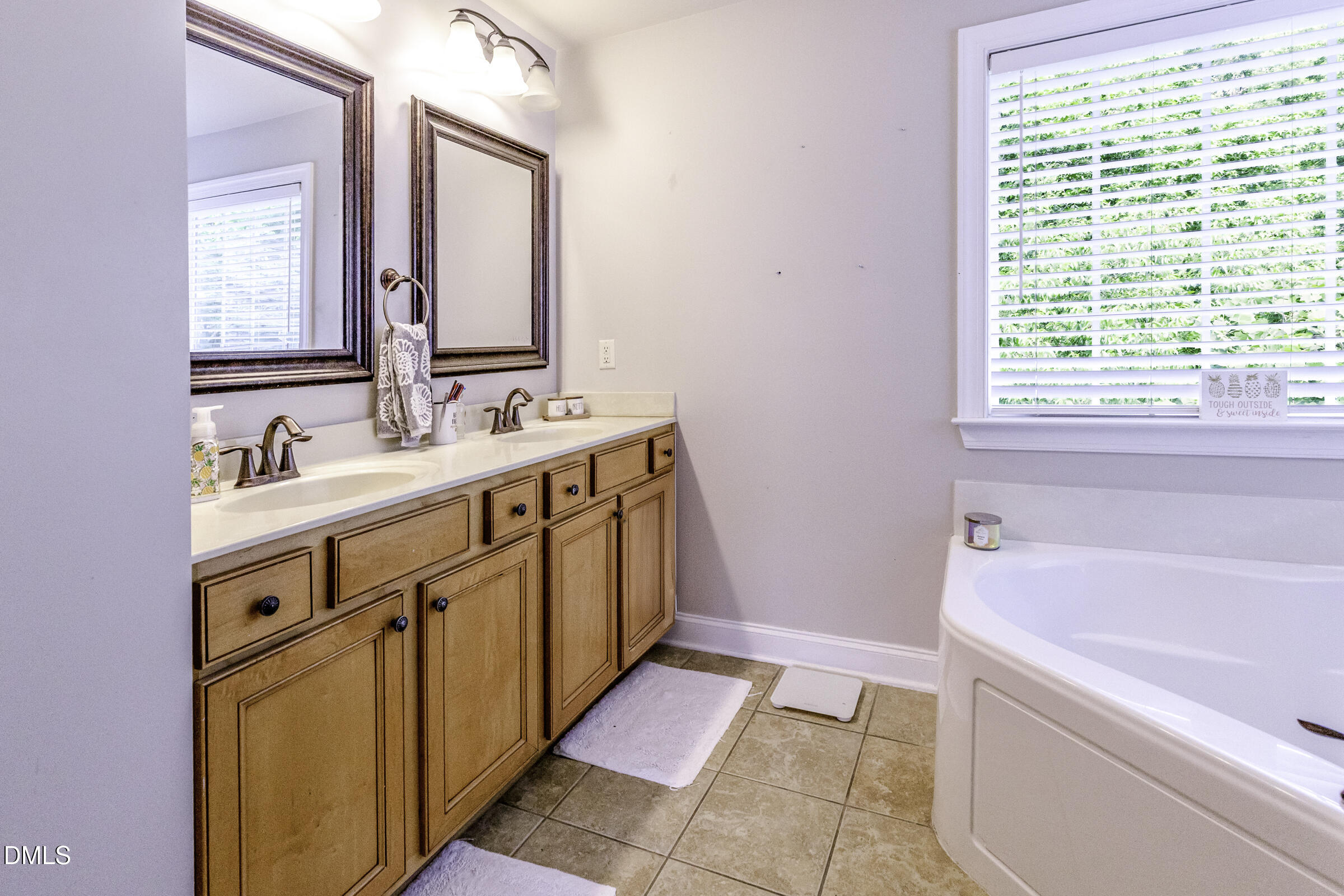 201 Quarryrock Road Holly Springs, NC 27540 - Photo 28 of 34 a bathroom with a sink a mirror and a bathtub