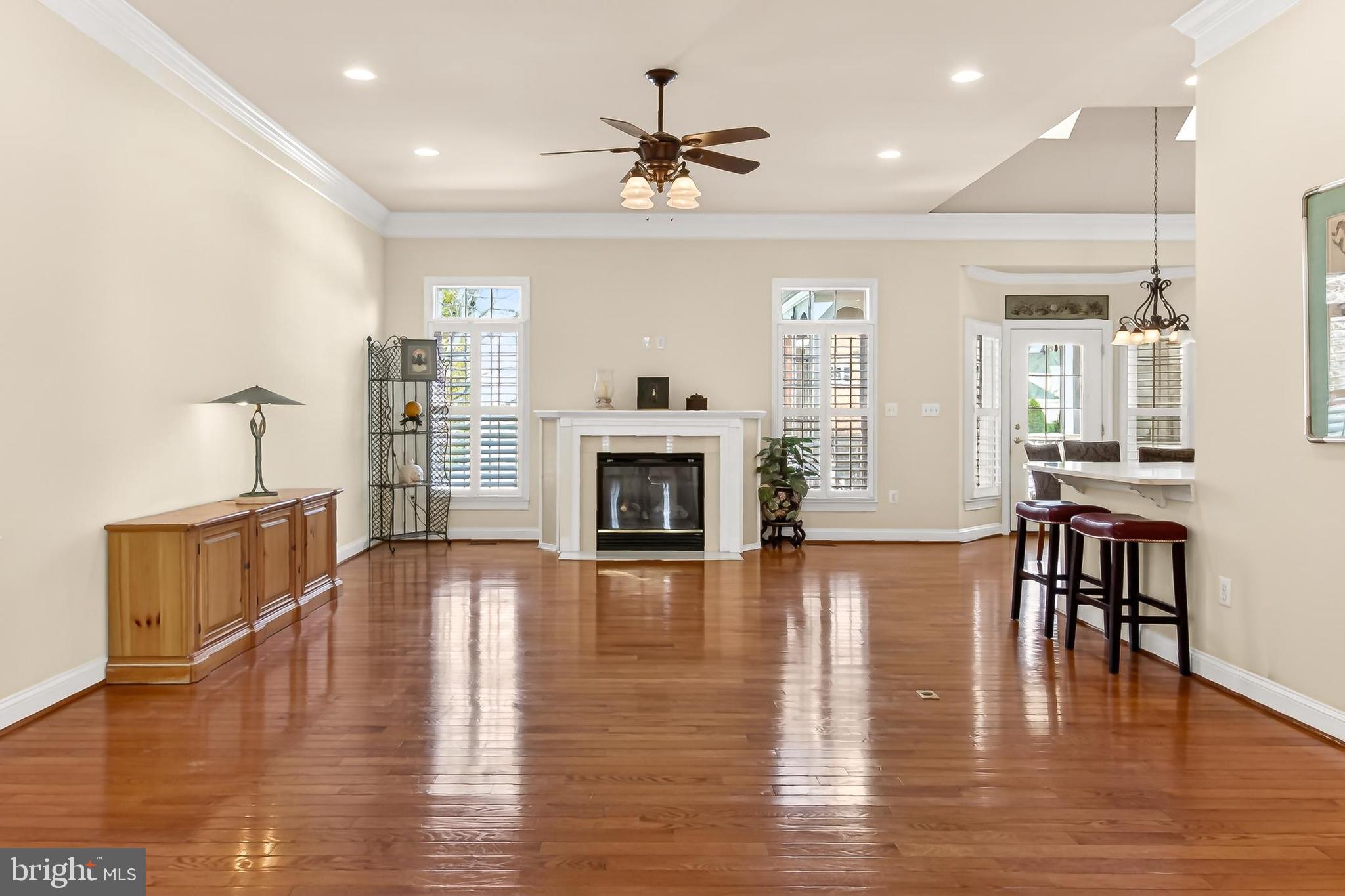 8471 Link Hills Loop Gainesville, VA 20155 - Photo 11 of 65 a view of a livingroom with furniture a fireplace wooden floor and a window