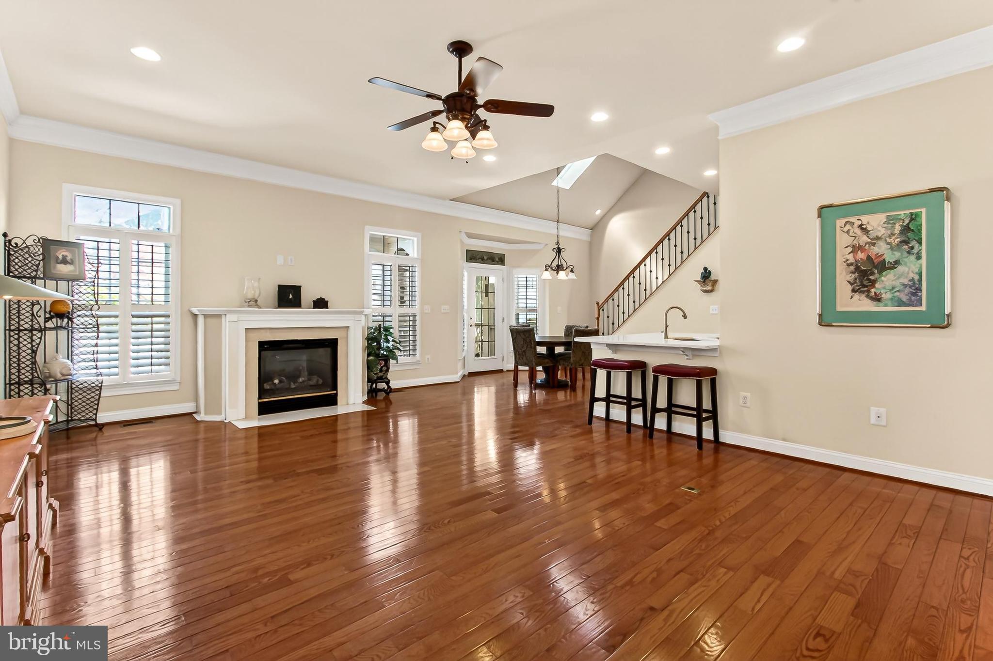 8471 Link Hills Loop Gainesville, VA 20155 - Photo 12 of 65 a view of a livingroom with fireplace a ceiling fan a fireplace and wooden floor
