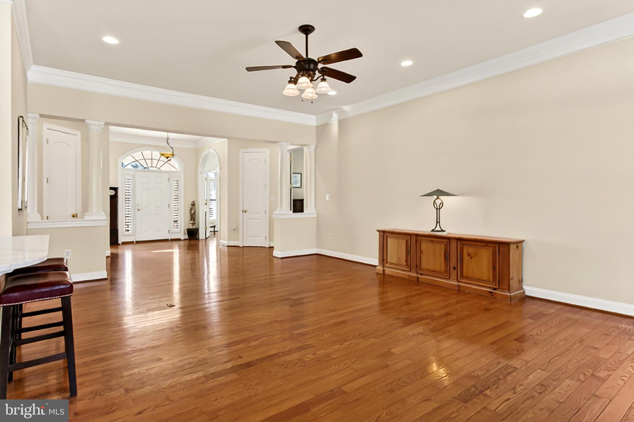 8471 Link Hills Loop Gainesville, VA 20155 - Photo 14 of 65 a view of a livingroom with a hardwood floor and a ceiling fan