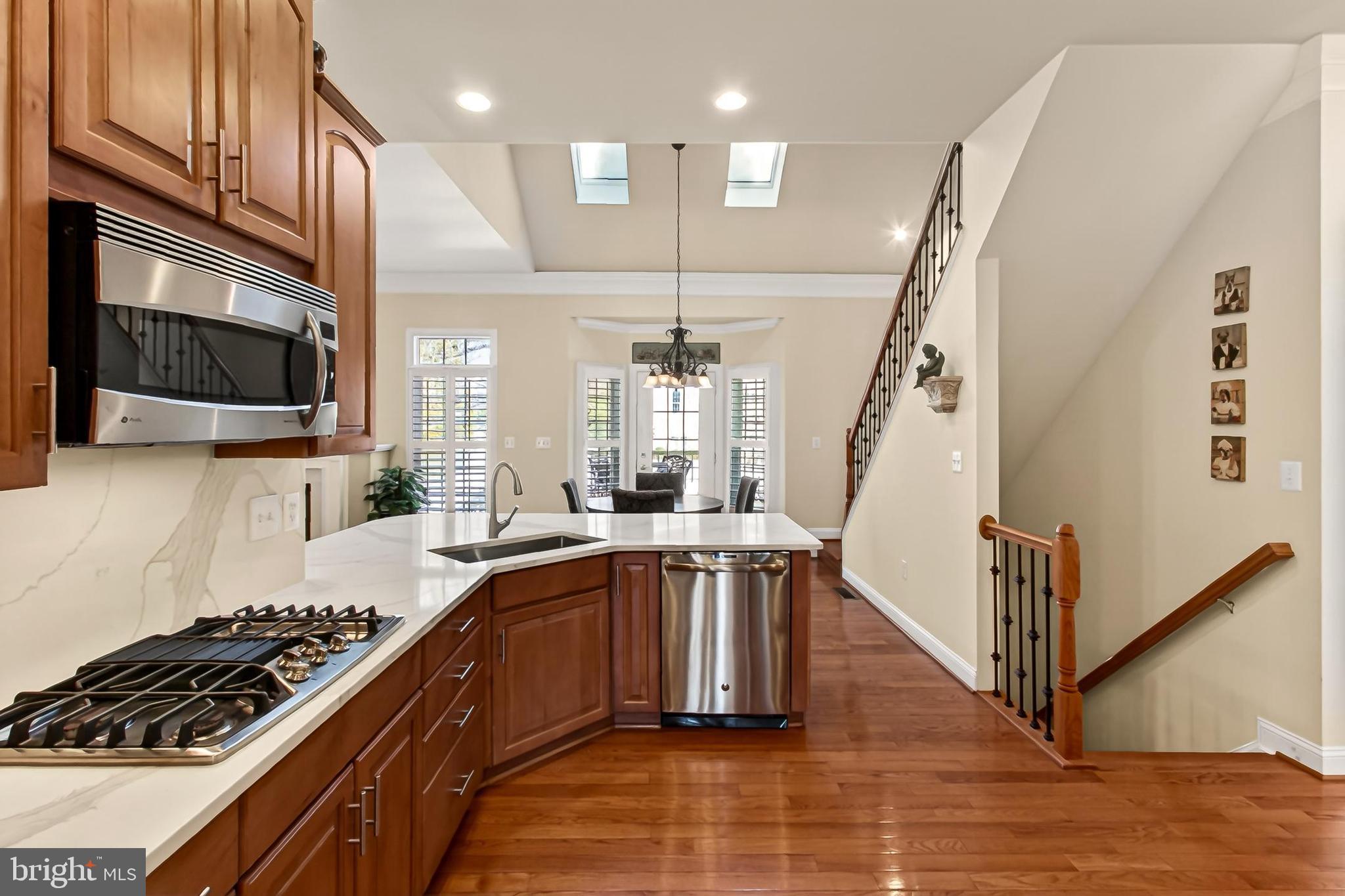 8471 Link Hills Loop Gainesville, VA 20155 - Photo 20 of 65 a kitchen with kitchen island granite countertop a sink a counter top space stainless steel appliances and cabinets