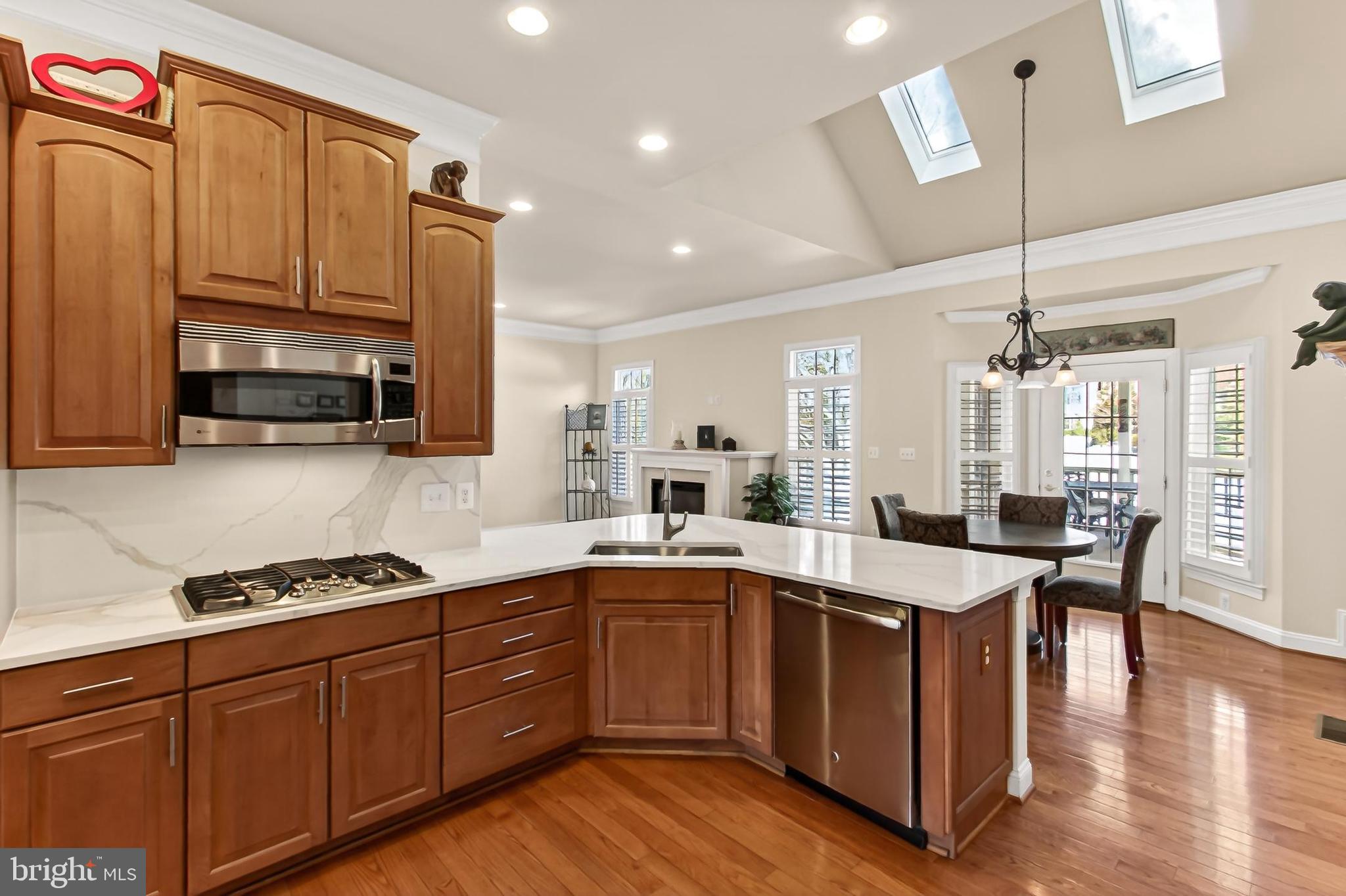 8471 Link Hills Loop Gainesville, VA 20155 - Photo 21 of 65 a kitchen with stainless steel appliances granite countertop a sink a stove and a wooden floors