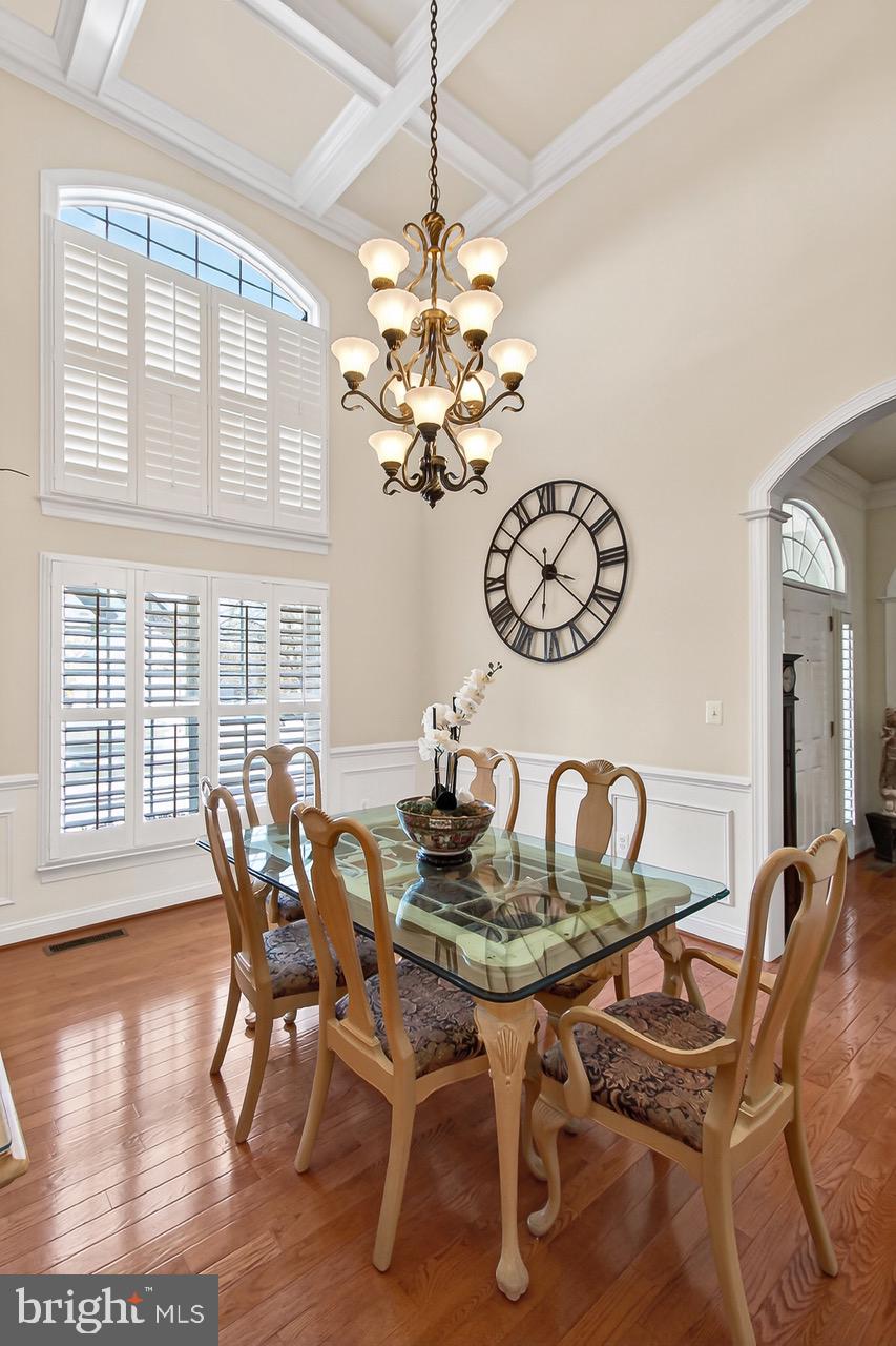 8471 Link Hills Loop Gainesville, VA 20155 - Photo 25 of 65 a dining room with furniture a chandelier and wooden floor