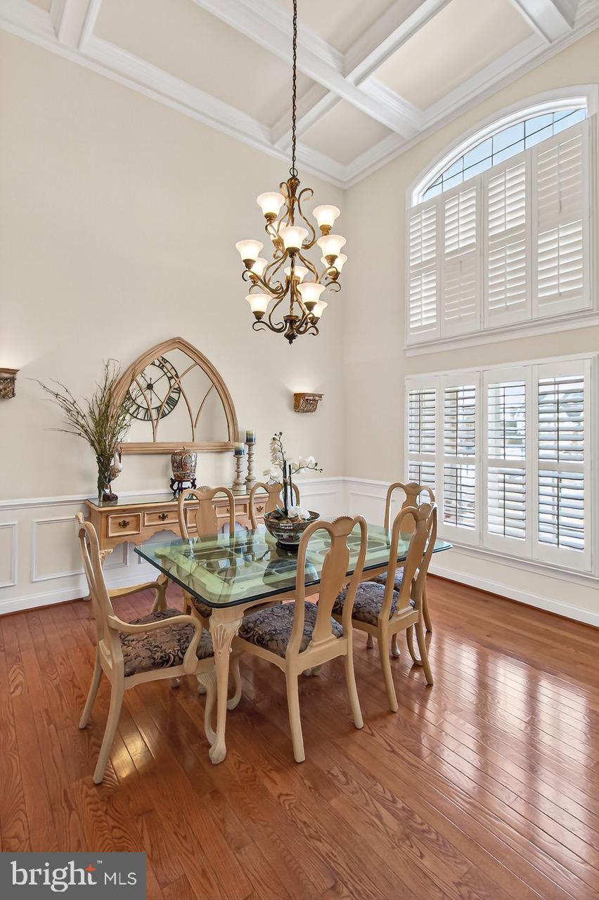 8471 Link Hills Loop Gainesville, VA 20155 - Photo 27 of 65 a view of a dining room with furniture a chandelier and wooden floor