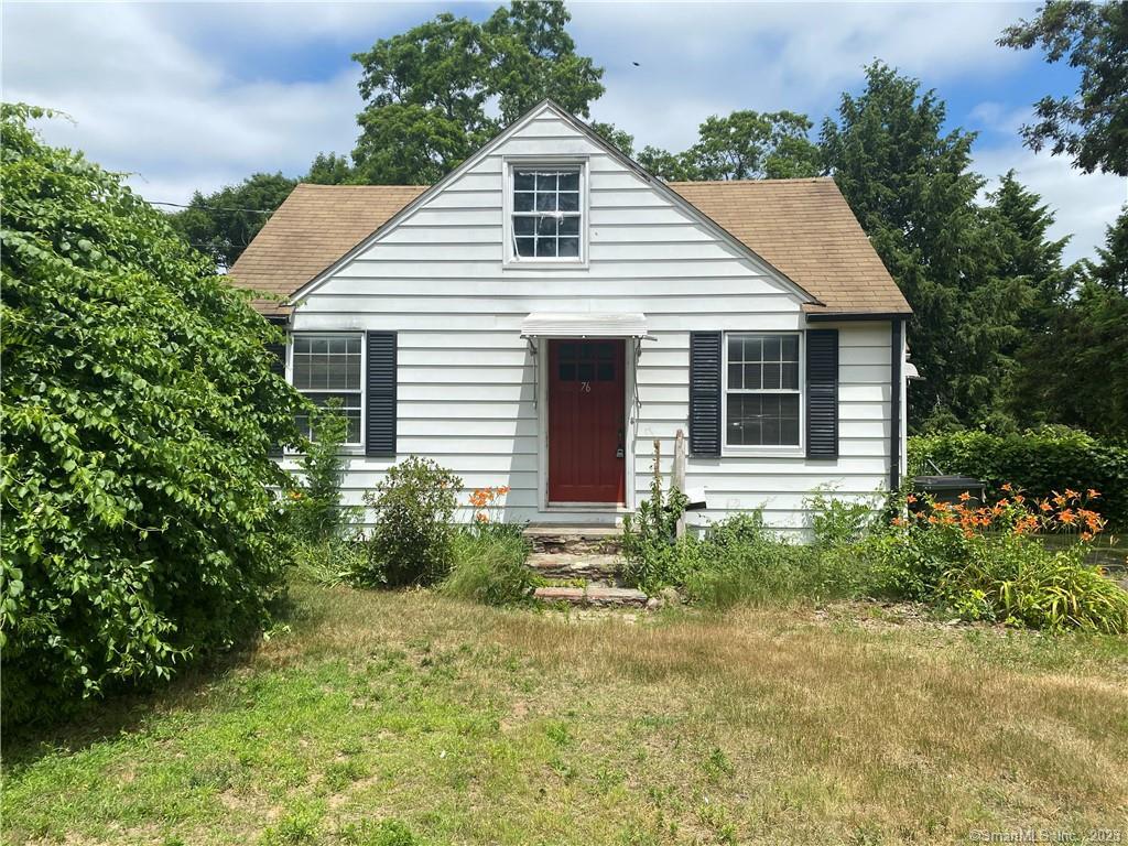 a view of a house with brick walls and a yard with plants