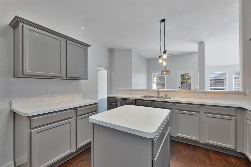 605 Clearbrook Street Azle, TX 76020 - Photo 7 of 33 Kitchen featuring gray cabinetry, white countertops, a central island, wood-finish flooring, and pendant lighting