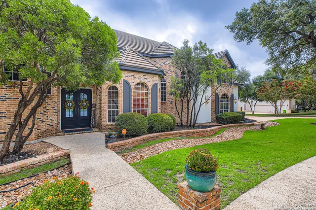 a front view of a house with a yard garden and outdoor seating