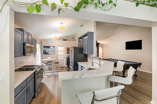 a kitchen with stainless steel appliances kitchen island granite countertop a stove and a refrigerator