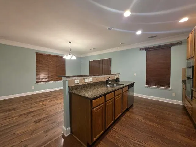 a kitchen with stainless steel appliances granite countertop a sink and a stove top oven
