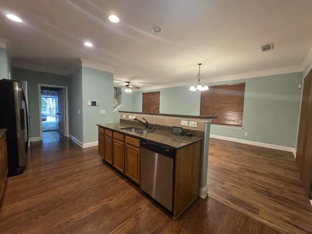 a large kitchen with stainless steel appliances granite countertop a lot of counter space and wooden floor