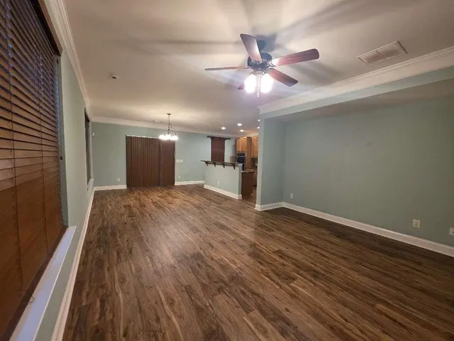 a view of a livingroom with a ceiling fan and wooden floor