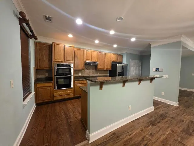 a view of kitchen with refrigerator microwave and stove