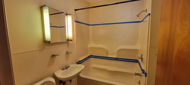 an empty room with wooden floor cabinet and windows