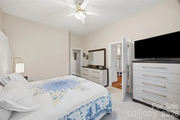 a bedroom with a bed and a flat screen tv in white walls
