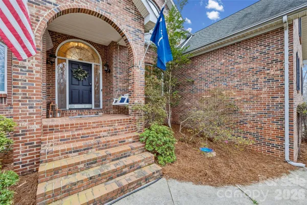 a view of a brick house with plants