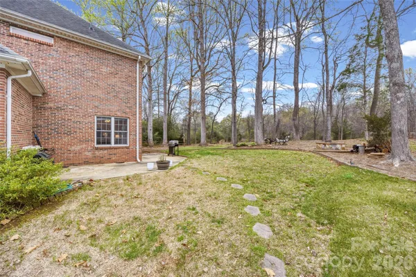 a view of a house with backyard and trees