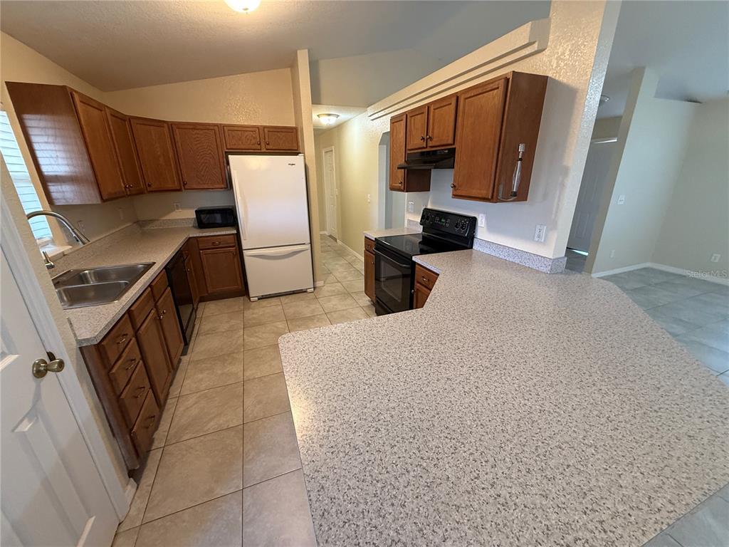 61 Laurel Drive Ocala, FL 34480 - Photo 3 of 14 a kitchen with stainless steel appliances a refrigerator a stove a microwave a sink and dishwasher