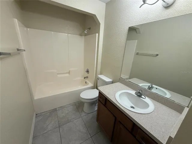 a bathroom with a granite countertop sink a toilet and shower