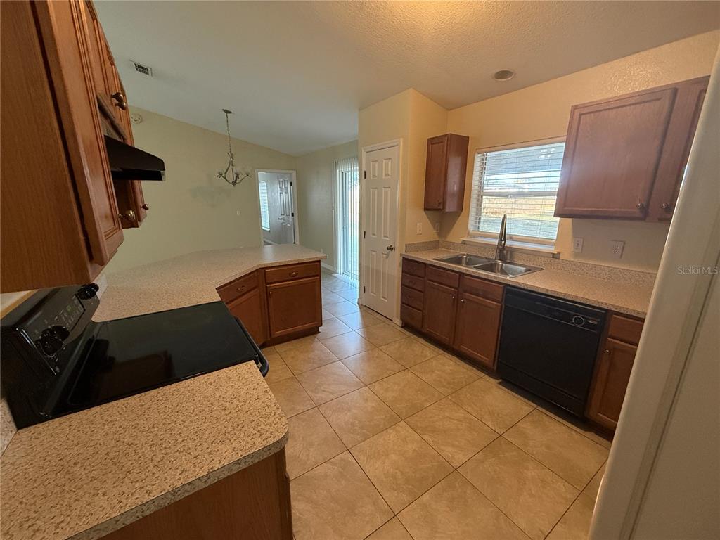 61 Laurel Drive Ocala, FL 34480 - Photo 8 of 14 a kitchen with granite countertop a sink a stove and refrigerator