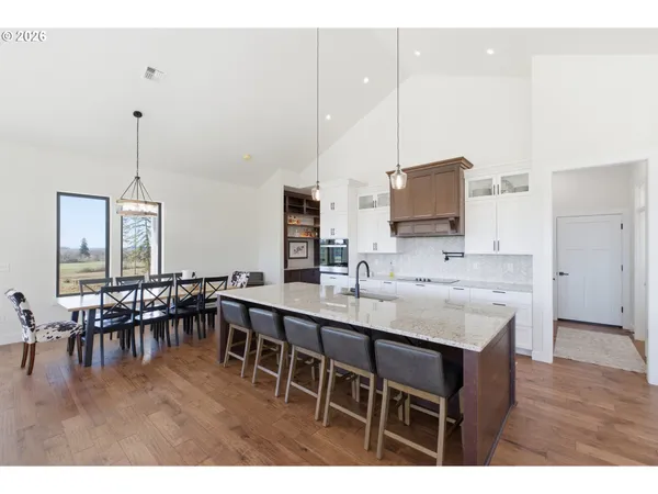 a kitchen with appliances a sink a dining table and chairs
