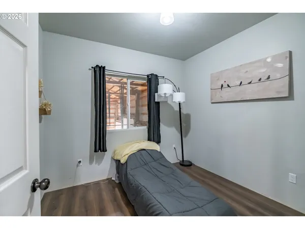 a view of a bedroom with wooden floor and a window