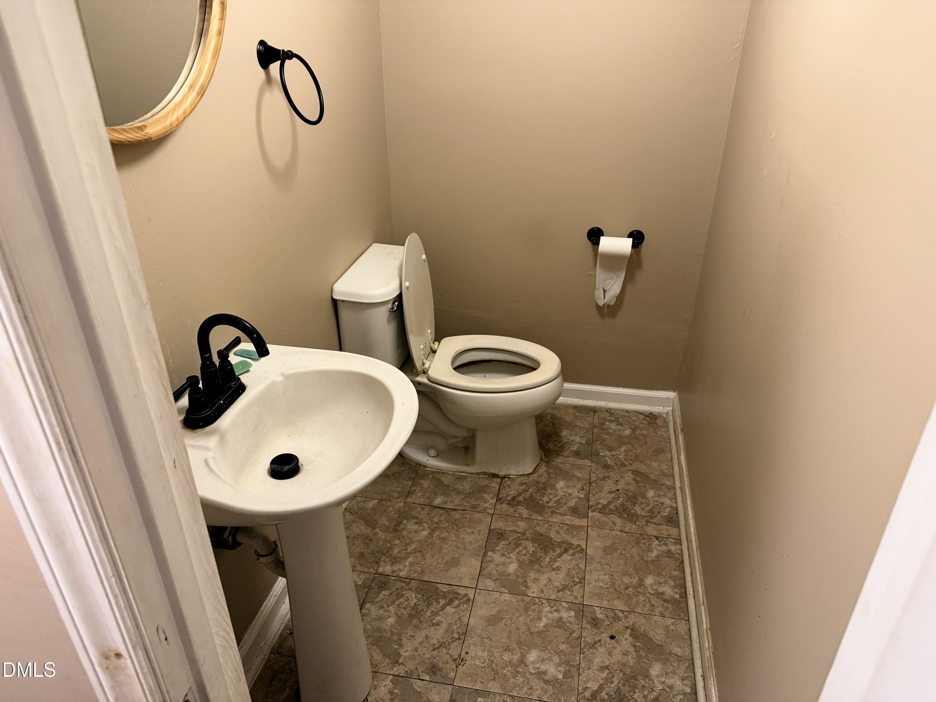 808 Campanella Lane Raleigh, NC 27610 - Photo 12 of 16 Pedestal sink with a black-finish faucet, toilet, and tiled flooring