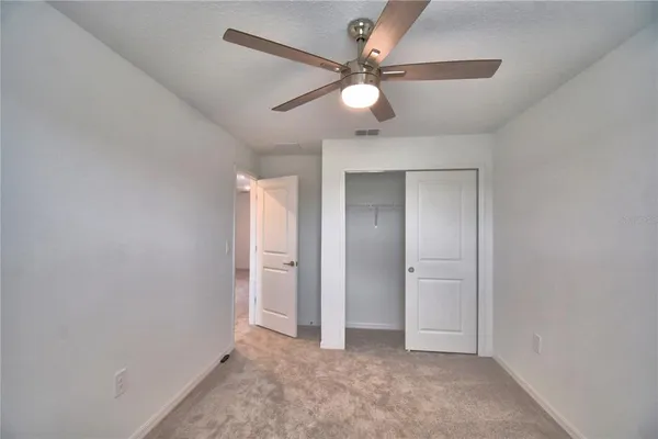 an empty room with a window and a fan