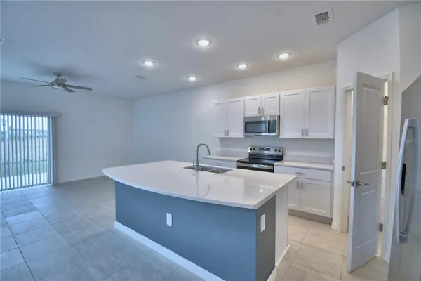a large room with a large window and stainless steel appliances