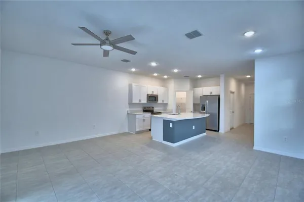 a view of kitchen with sink refrigerator and window