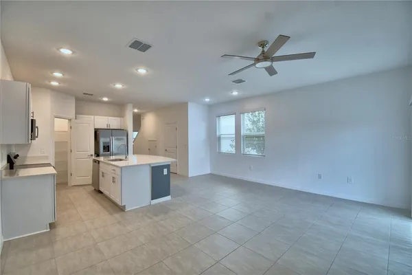 a kitchen with a sink a microwave a refrigerator and white cabinets