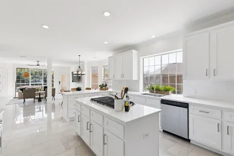 a kitchen that has a sink a stove counter top space and cabinets