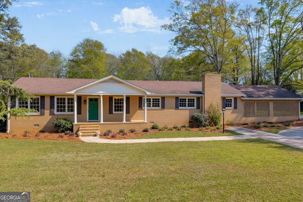 a front view of a house with yard porch and furniture