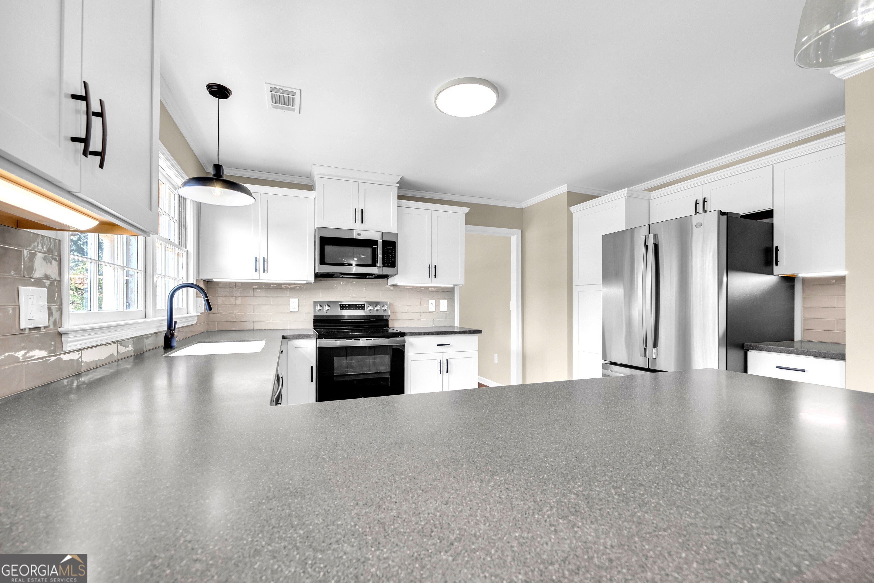 100 Broad Street Bowman, GA 30624 - Photo 11 of 65 a large kitchen with stainless steel appliances granite countertop a refrigerator a stove a sink dishwasher with a dining table and chairs