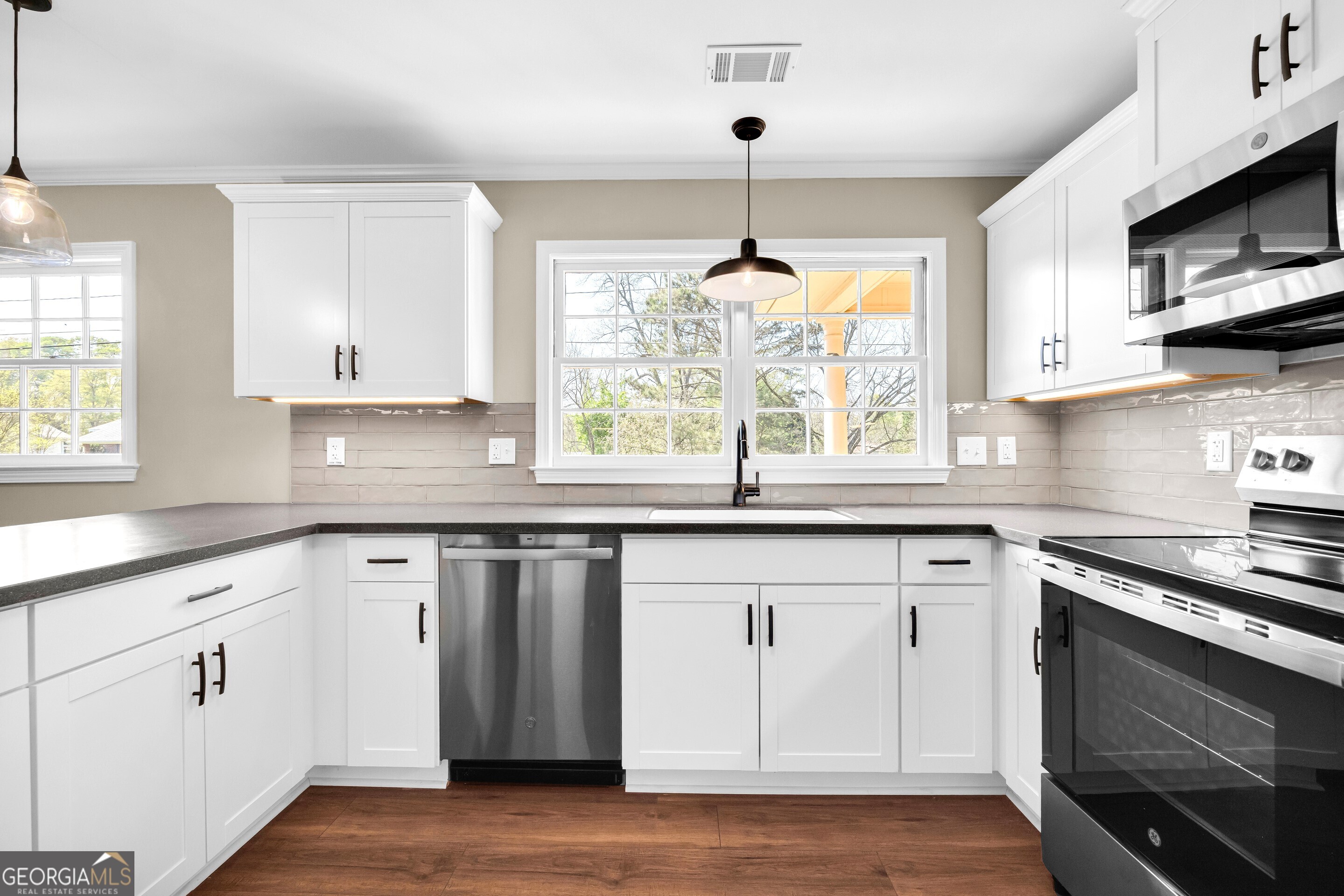 100 Broad Street Bowman, GA 30624 - Photo 13 of 65 a kitchen with stainless steel appliances granite countertop a sink a stove and cabinets