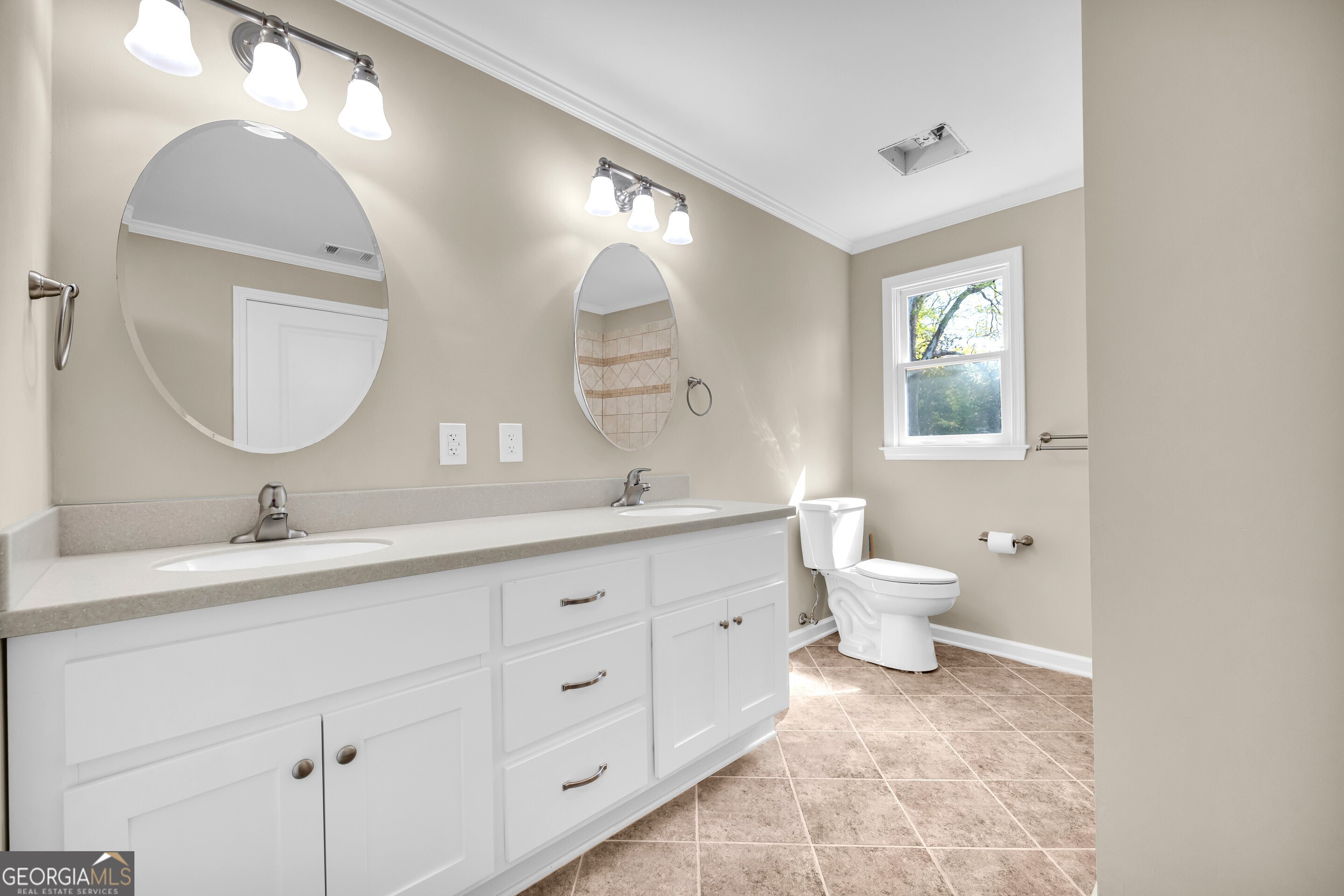 100 Broad Street Bowman, GA 30624 - Photo 32 of 65 a bathroom with a toilet a double vanity sink and a mirror