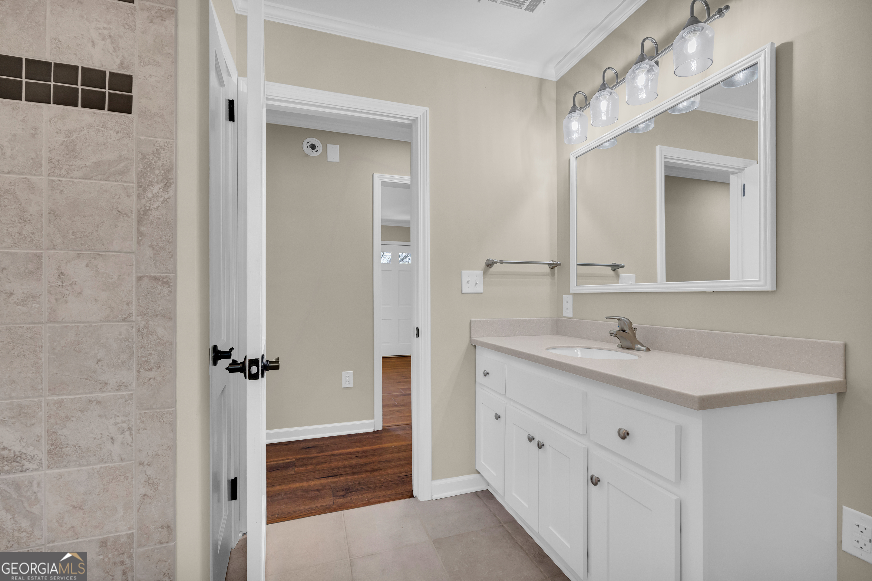 100 Broad Street Bowman, GA 30624 - Photo 42 of 65 a bathroom with a double vanity sink a mirror and a shower