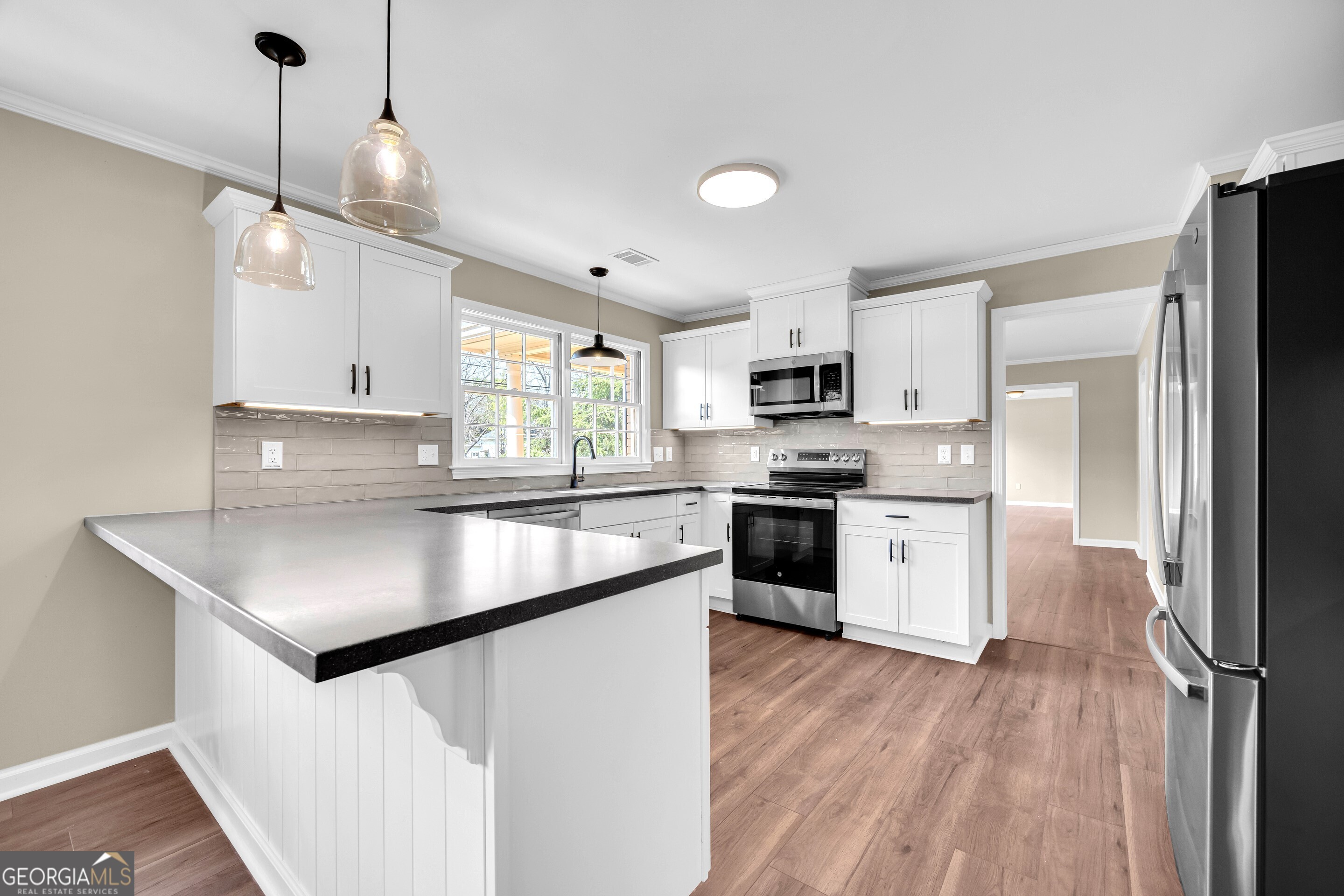100 Broad Street Bowman, GA 30624 - Photo 10 of 65 a kitchen with stainless steel appliances granite countertop a sink a stove a refrigerator and island with wooden floor