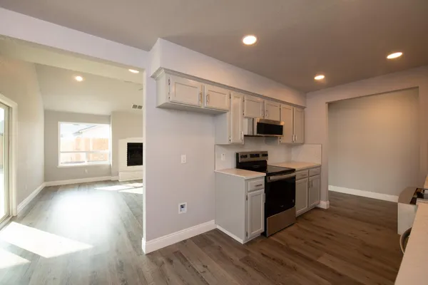 a kitchen with stainless steel appliances kitchen island granite countertop a stove a sink and a refrigerator