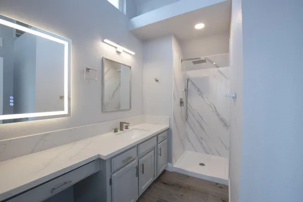 a bathroom with a shower sink and mirror