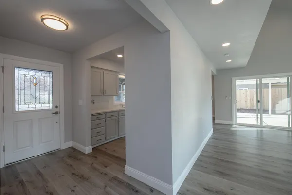 an empty room with wooden floor and windows