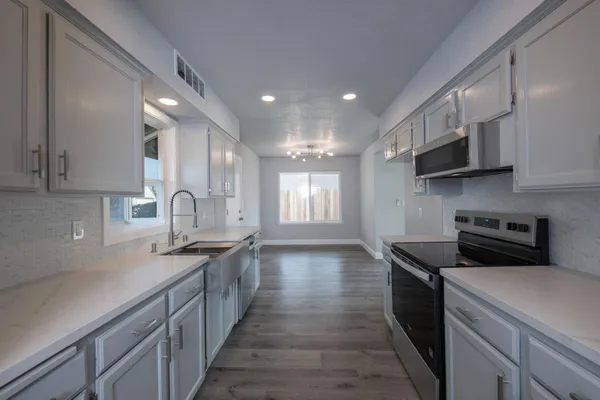 a kitchen with stainless steel appliances granite countertop a sink stove and cabinets