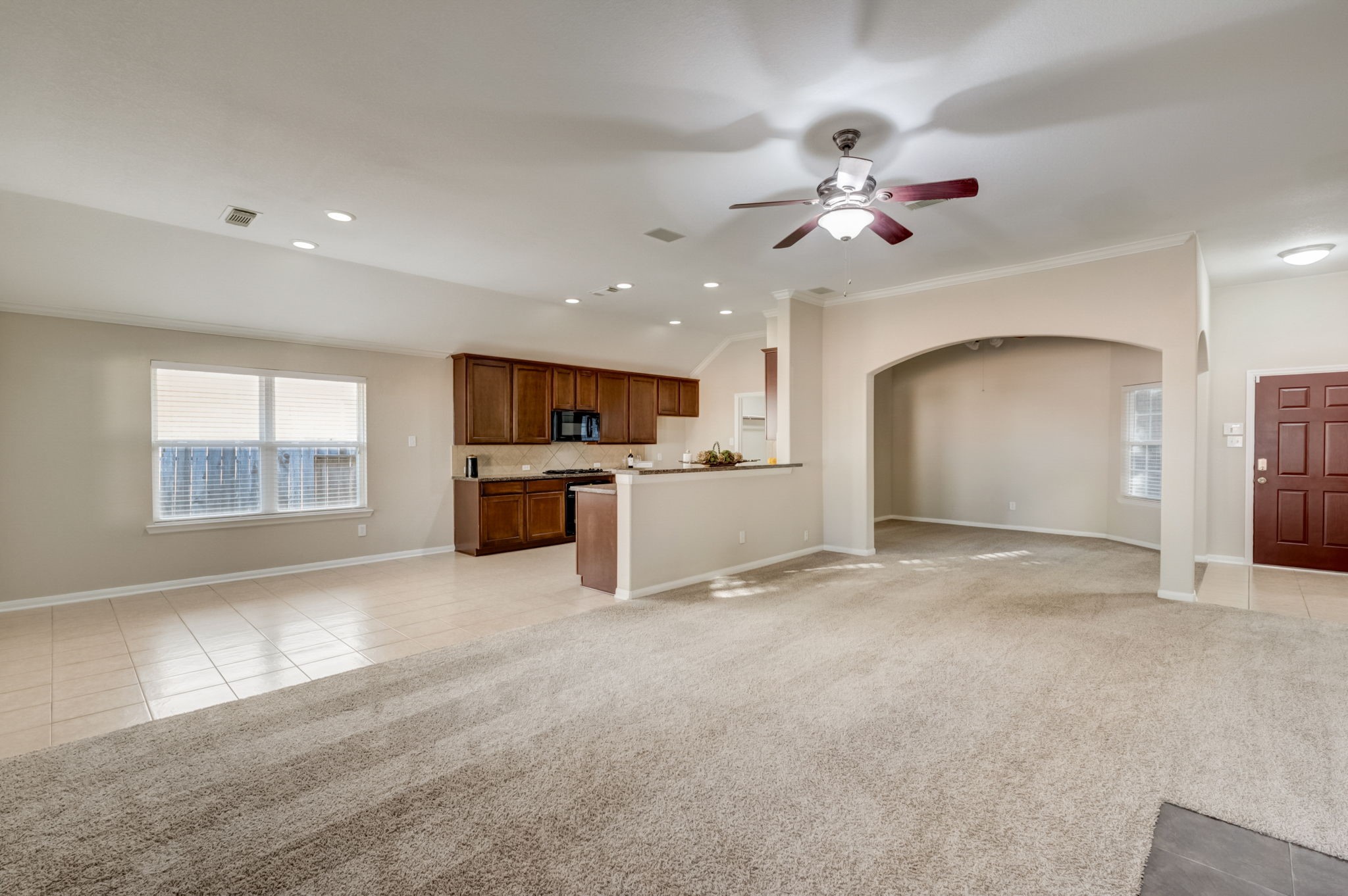 7219 Palmito Ranch Drive Richmond, TX 77406 - Photo 12 of 32 a view of a kitchen with a stove cabinets a ceiling fan and wooden floor