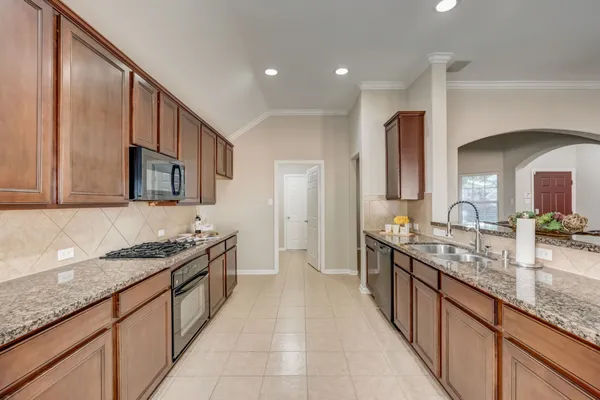 a kitchen with stainless steel appliances granite countertop a sink and stove top oven